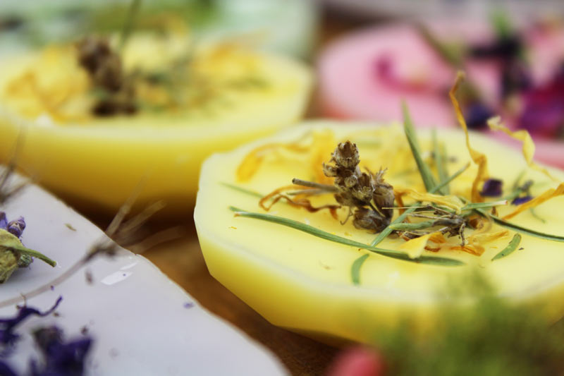 Vackra vaxkakor med blommor, torkade bär och torkade växter.